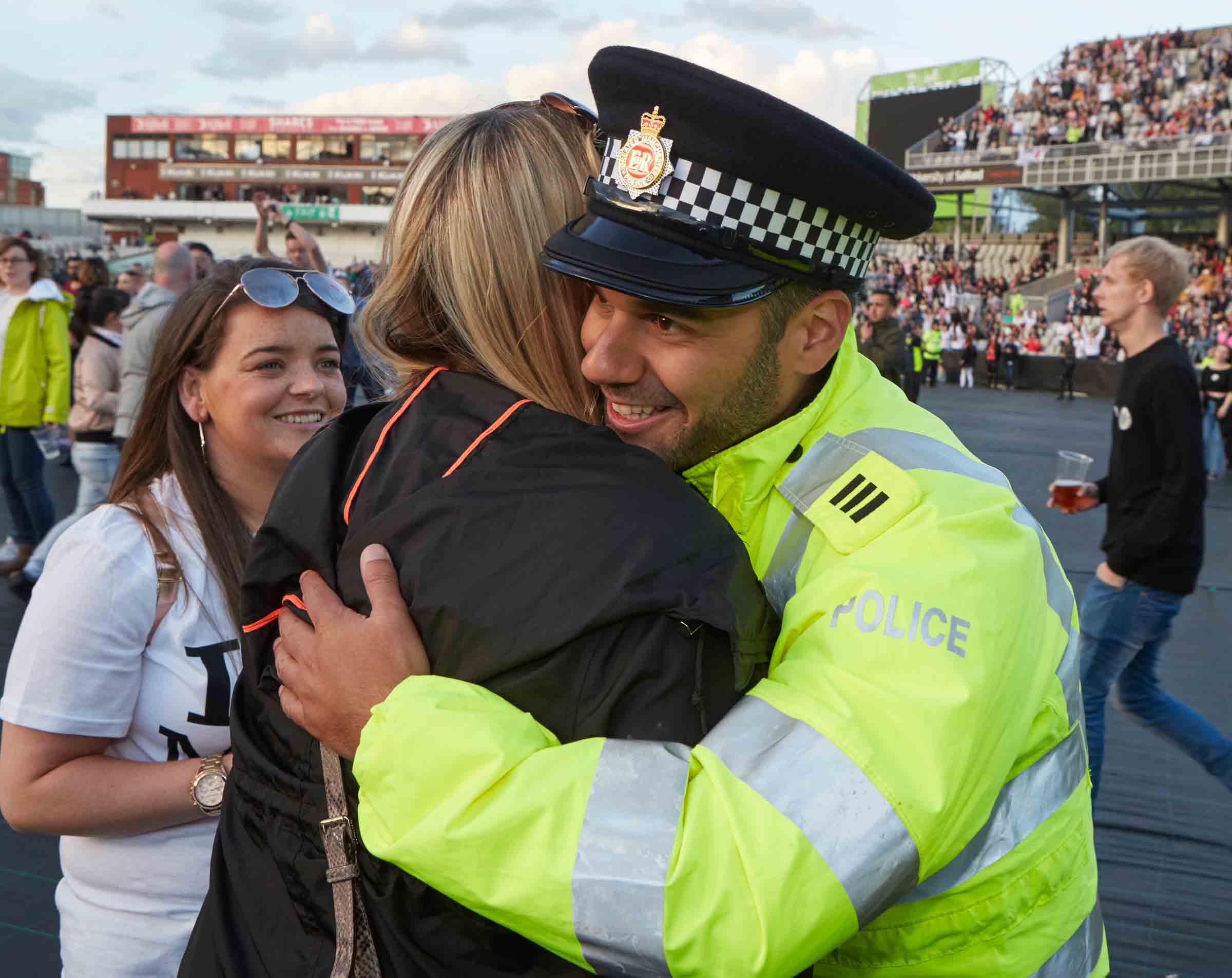 A photograph shows a Greater Manchester Police officer embracing a member of the public at the One Love concert in Manchester in June 2017