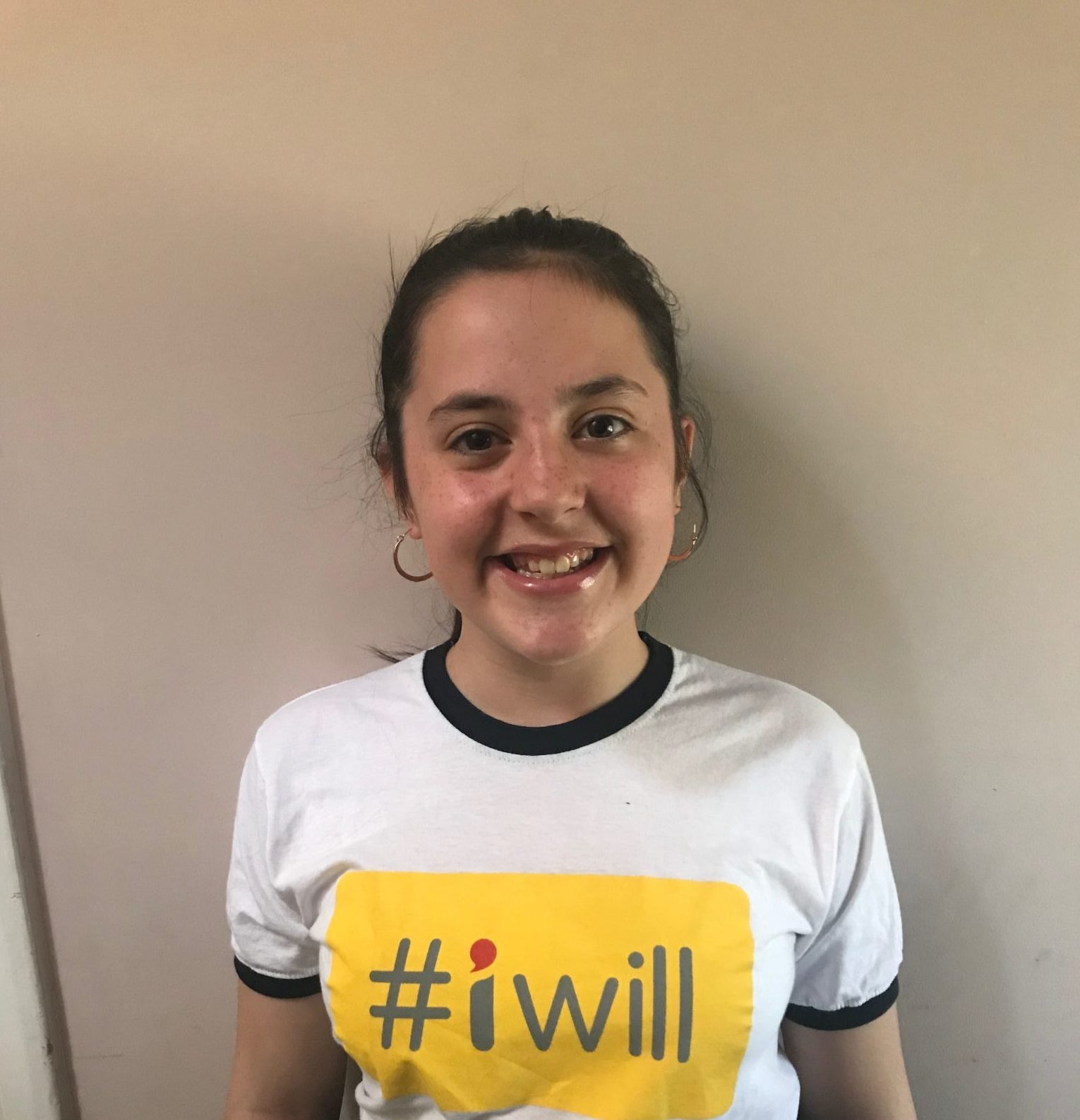 Picture of Ella smiling and wearing a t-shirt with the #iwill logo on