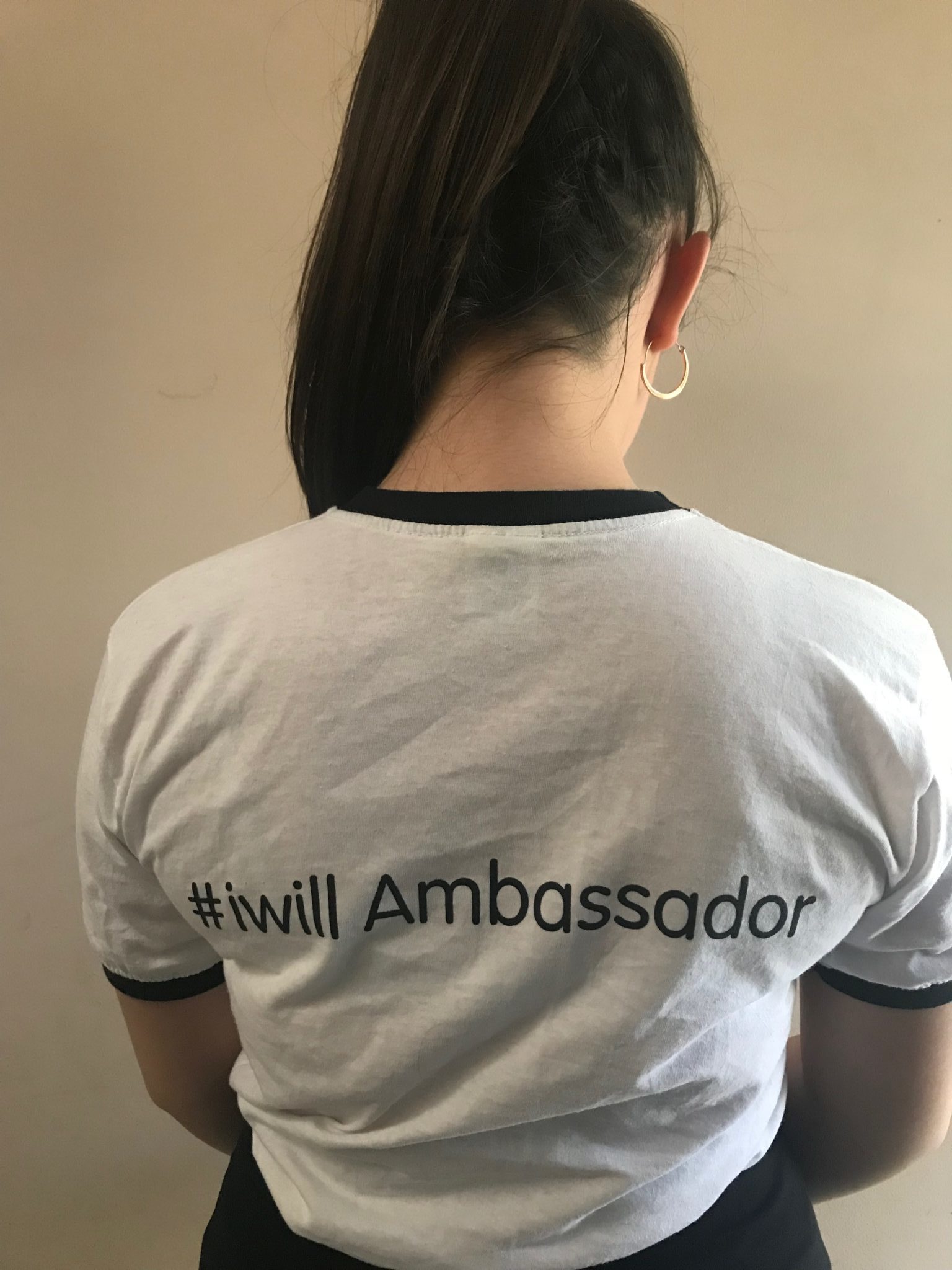 Picture of Ella smiling and wearing a t-shirt with '#iwill Ambassador' written on the back