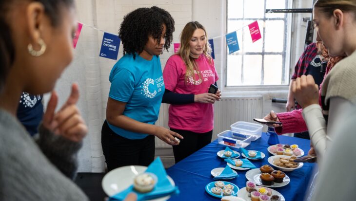 People attend a bake sale for Cancer Research UK